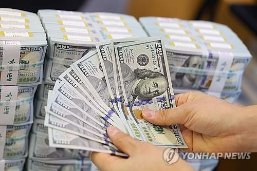 This file photo taken Dec. 19, 2024, shows a clerk checking U.S. dollar notes at a center of Hana Bank in Seoul. (Yonhap)