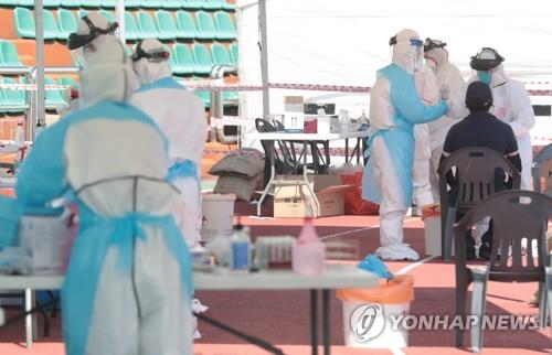 Des personnels de santé effectuent des tests dans un centre de dépistage à Jeju le vendredi 17 juillet 2020. 