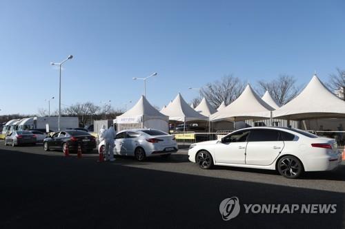 Des automobilistes attendent de subir un test de dépistage pour le nouveau coronavirus (Covid-19) dans un centre au volant à Goyang, dans la province du Gyeonggi, le mercredi 30 décembre 2020. 