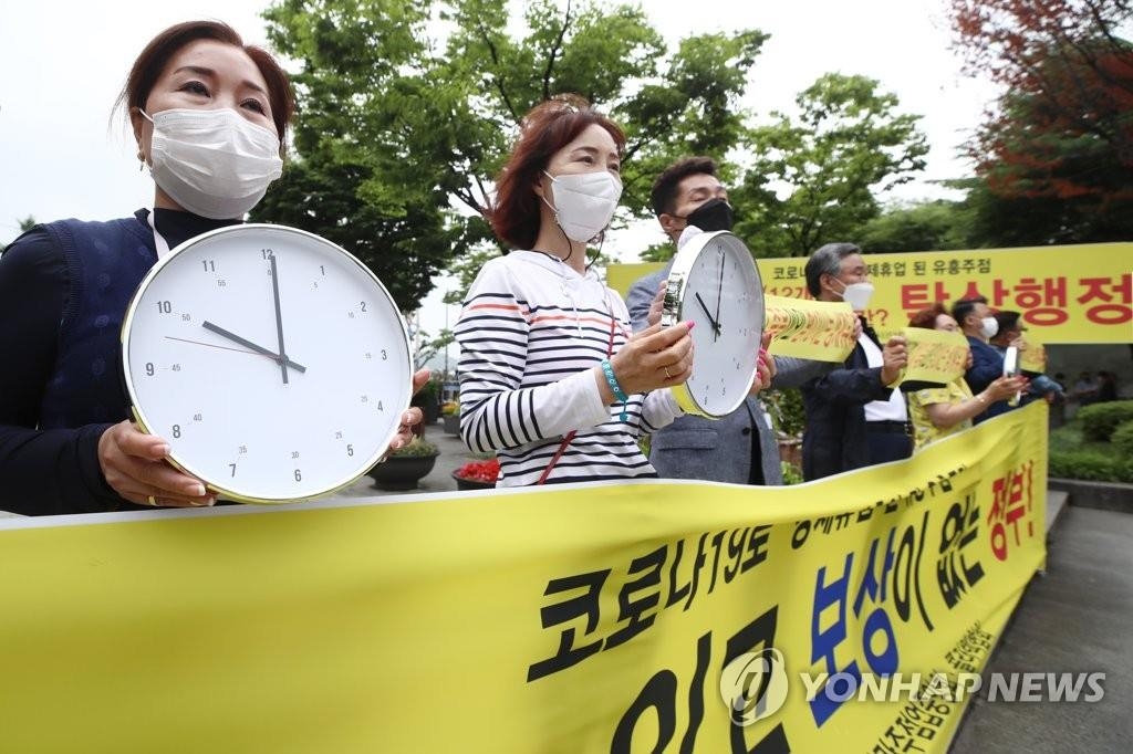Les propriétaires d'installations de divertissement pour adultes organisent une manifestation dans le centre de Séoul le 18 juin 2021, exhortant la Corée du Sud à lever les restrictions sur leurs heures d'ouverture.