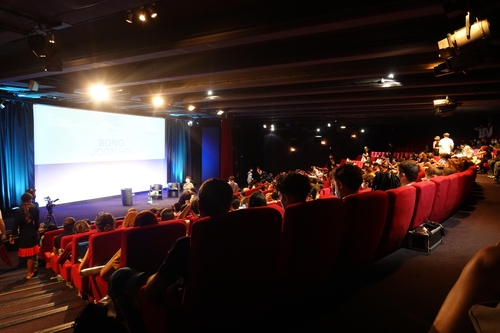 Des spectateurs attendent l'arrivée de Bong Joon-ho à la salle Buñuel du Palais des festivals à Cannes, le mercredi 7 juillet 2021 (heure locale) .