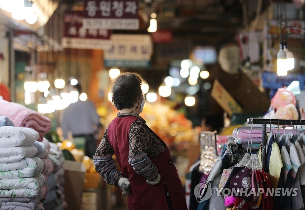 Une commerçante se prépare à ouvrir son magasin le jeudi 12 mai 2022 au marché traditionnel de Gwangjang à Séoul.