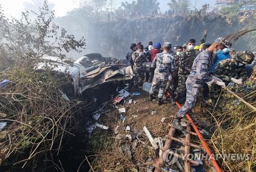 Des équipes de secours travaillent autour de l'épave de l'avion de Yeti Airlines après son crash à Pokhara au Népal, le dimanche 15 janvier 2023. (EPA=Yonhap) 