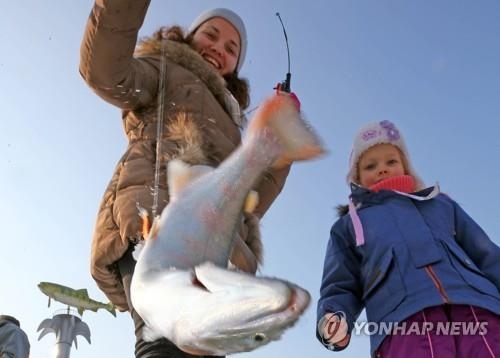 氷上釣りを楽しむ外国人観光客＝華川（聯合ニュース）