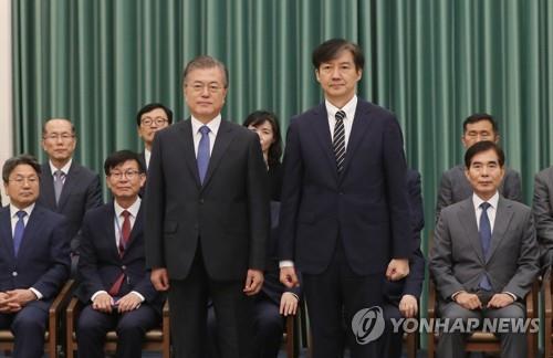 任命状を授与した後、記念撮影する文大統領（左）とチョ長官＝９日、ソウル（聯合ニュース）