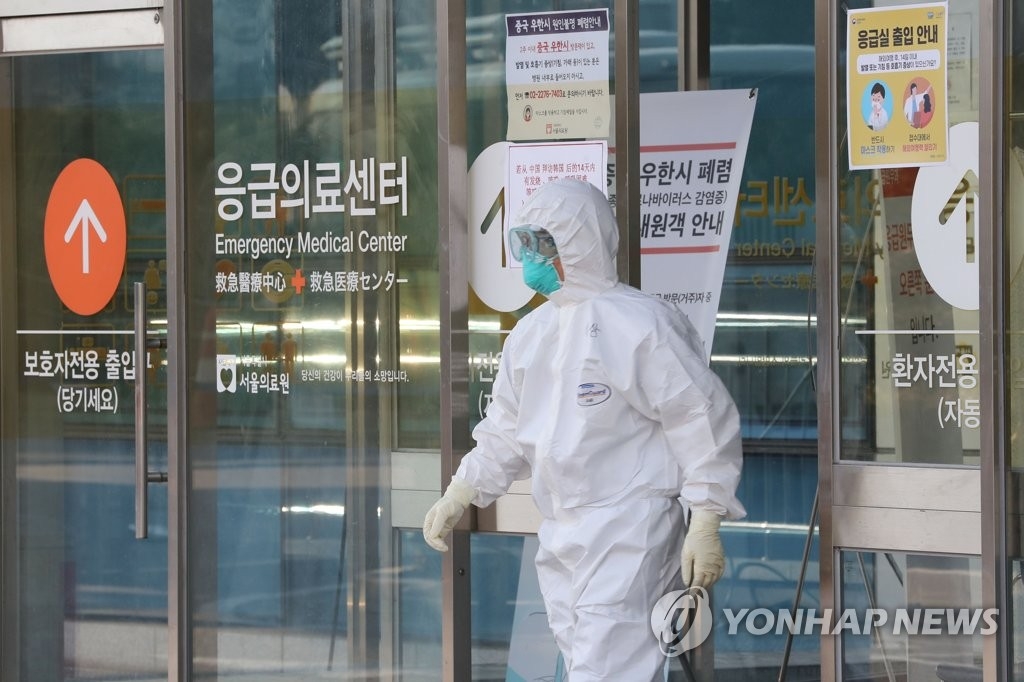 患者が入院している病院に防護服を着た関係者が出入りしている＝３日、ソウル（聯合ニュース）