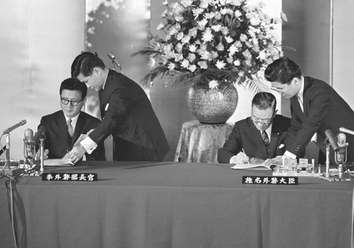 １９６５年６月２２日、東京で基本条約に署名する李東元（イ・ドンウォン）外務部長官（左）と椎名悦三郎外相＝（共同＝聯合ニュース）
