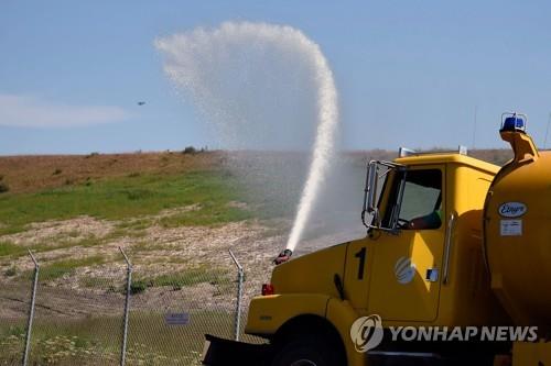 지난 4일 알래스카의 테드 스티븐스 앵커리지국제공항 주변에서 이뤄지는 물뿌리기 작업[출처: 게티이미지]