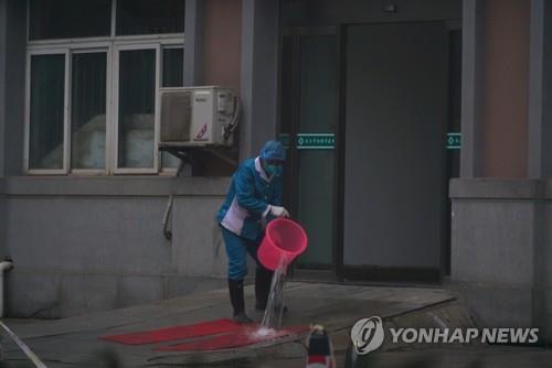 중국 우한의 병원 입구에서 청소 중인 직원