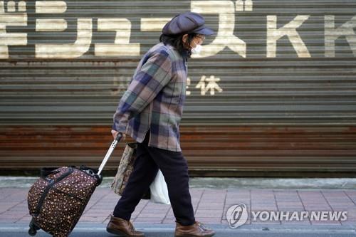 (도쿄 AP=연합뉴스) 신종 코로나바이러스 감염증(코로나19)으로 긴급사태가 선포된 가운데 14일 일본 도쿄도(東京都)에서 마스크를 쓴 여성이 상점가를 걷고 있다. 2020.4.25