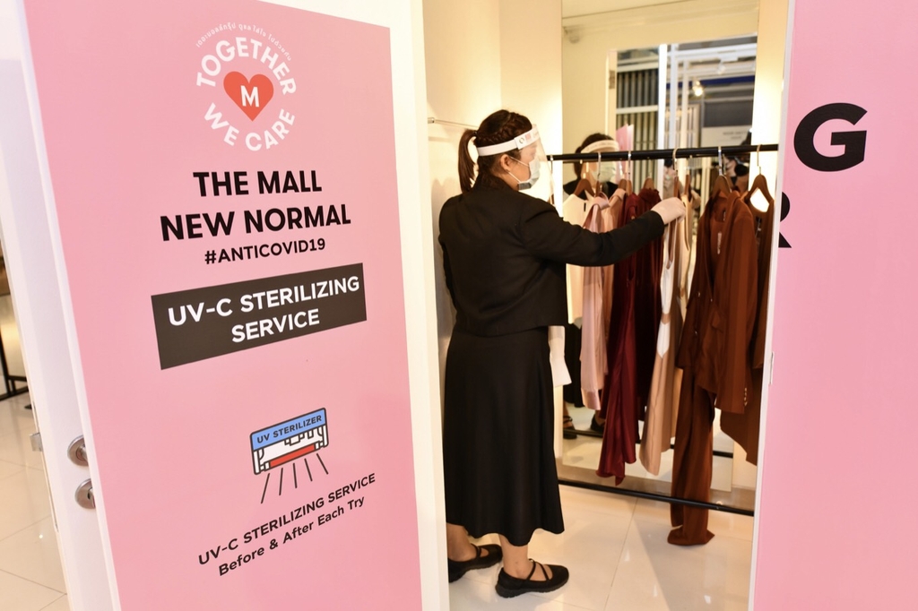 A staff of the Mall preparing to sterilized clothes at the UV- C Sterilizing Chamber