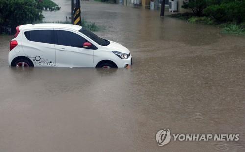 지난 24일 오전 강원 강릉 시내의 한 도로에서 차량이 침수돼 멈춰서 있다. [연합뉴스 자료 사진]