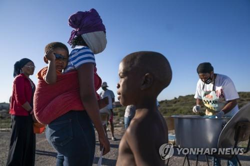 지난 4월 28일 남아공 케이프타운 빈민가 사람들이 구호식품을 받고 있다.