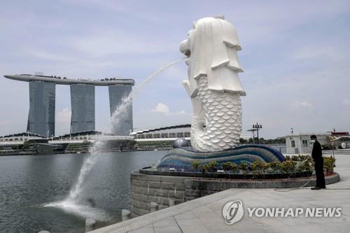 싱가포르 상징 멀라이언 동상(앞쪽)과 마리나 베이 샌즈 호텔(자료사진)
