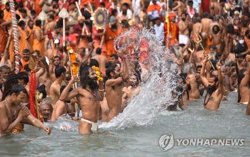12일 인도 하리드와르의 갠지스강변에서 진행된 쿰브멜라 축제.참가가 대부분은 노마스크 상태로 물에 들어가 축제를 즐겼다. [EPA=연합뉴스]