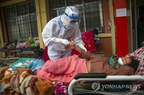 네팔 수도 카트만두의 한 병원 응급실 밖에서 치료받는 코로나19 환자. [AP=연합뉴스]