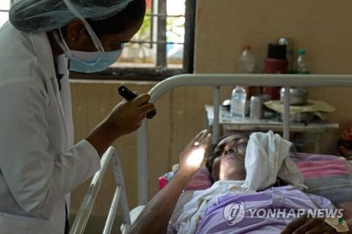 인도 하이데라바드의 한 병원에서 곰팡이균에 감염된 환자를 치료하는 의사(왼쪽). [AFP=연합뉴스]