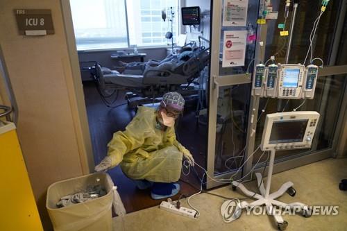지난달 미 루이지애나주 윌리스-나이튼 의료센터의 중환자실(ICU)에서 코로나19 환자가 치료받는 가운데 간호사가 의료기기를 옮기고 있다. [AP=연합뉴스]