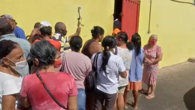 소뼈와 소고기 찌꺼기를 나눠주는 정육점 앞에 줄을 선 브라질 주민들
