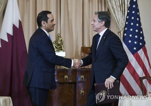 이익대표국 합의후 악수하는 미국과 카타르 외교장관