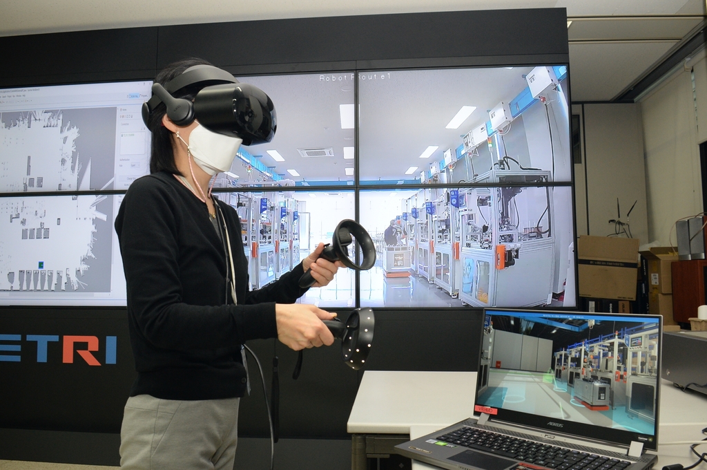 ETRI 연구진이 현장 스마트공장, 로봇 상황과 연동되는 가상현실(VR) 기기로 현장을 점검하고 있는 모습. [한국전자통신연구원(ETRI) 제공. 재판매 및 DB 금지]