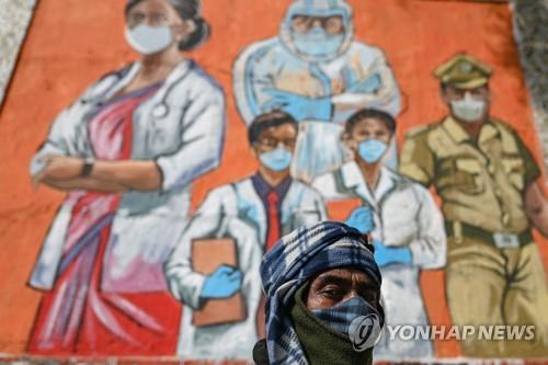  인도 뉴델리의 코로나19 방역 벽화 앞에 서 있는 시민.