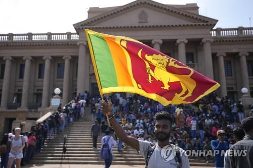 7월 13일 대통령 집무동 앞에서 국기를 흔드는 스리랑카 시위대