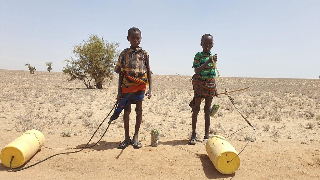 가뭄에 물통 끌고 가는 투르카나 아이들 