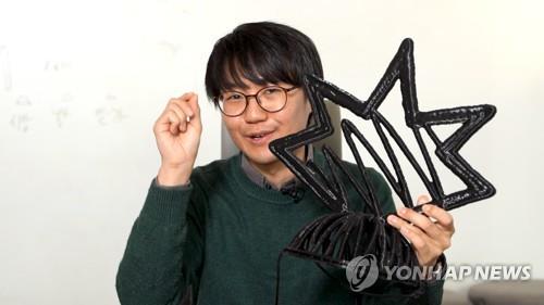 김용관 스케치소프트 대표가 3D 프린터로 출력한 자사 로고 모양의 창작물을 들고 3D 스케치북 '페더'에 대해 설명하고 있다.