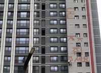 신축아파트 외벽에 '돈 주세요'…로프 타고 고공 시위한 50대