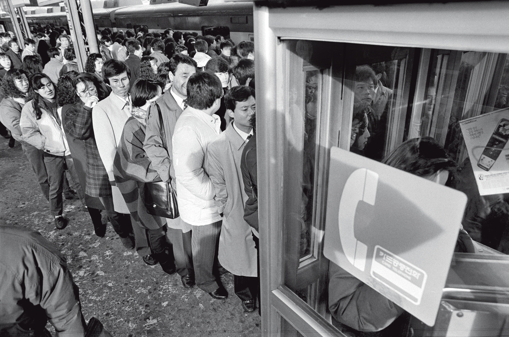 전철 승강장 공중전화 부스 앞에서 통화 순서를 기다리는 시민들. 1991년 [연합뉴스 자료사진]