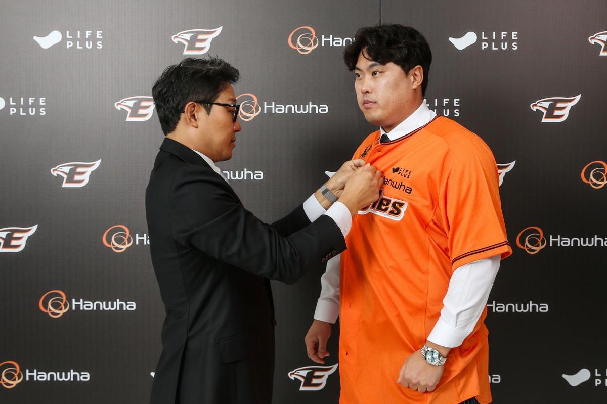 류현진의 유니폼 단추를 채워주는 박찬혁 한화 이글스 대표 이사