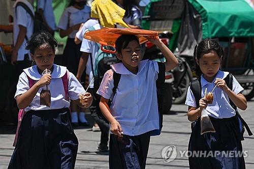 필리핀 마닐라에서 2일 폭염 속을 걷고 있는 학생들.