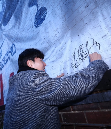 벽화에 서명을 남기는 손흥민