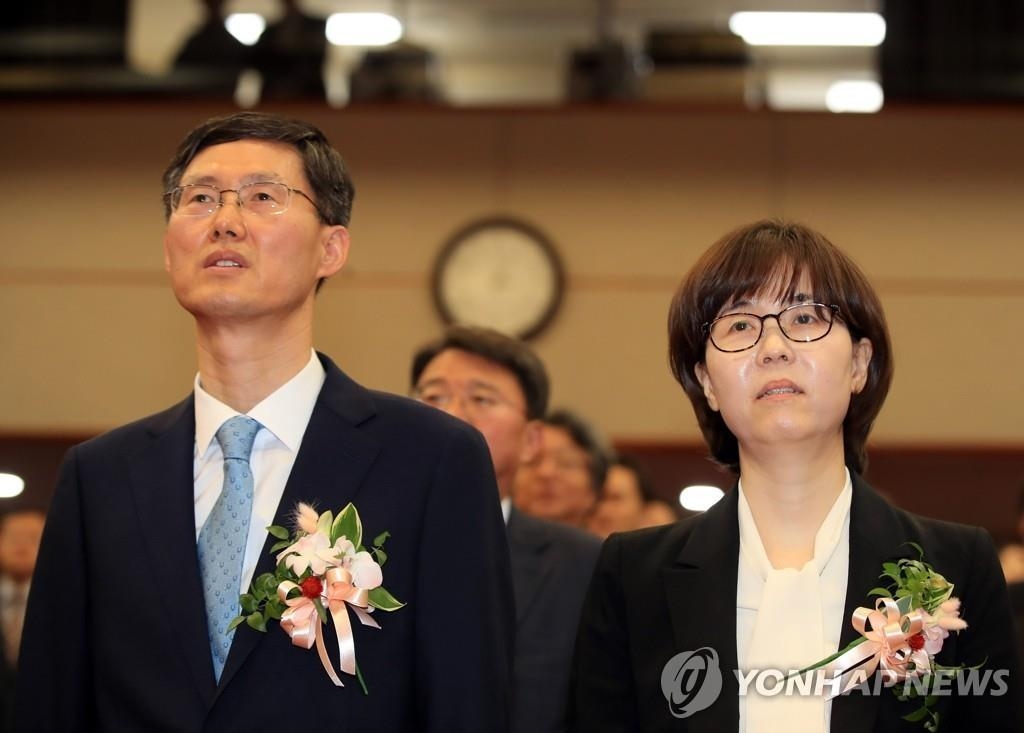 Los jueces constitucionales recientemente nombrados, Moon Hyung-bae (izda.) y Lee Mi-sun, atienden a una ceremonia de investidura en Seúl el 19 de abril de 2019.