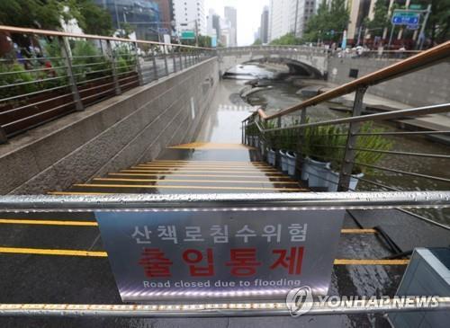 La foto de archivo muestra un letrero que anuncia la restricción de la entrada a un popular sendero a lo largo del arroyo Cheonggye, que cruza el centro de Seúl.