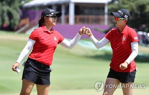 Las golfistas surcoreanas Kim Sei-young (izda.) y Kim Hyo-joo chocan el puño tras completar la tercera ronda del torneo de golf femenino de los Juegos Olímpicos de Tokio, el 6 de agosto de 2021, en el Club de Campo de Kasumigaseki, en Saitama, Japón. 
