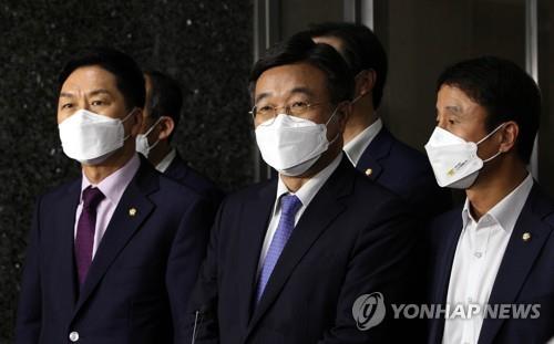 Esta foto proporcionada por el cuerpo de prensa de la Asamblea Nacional muestra a los legisladores Kim Gi-hyeon (izda.) y Yun Ho-jung (centro), líderes parlamentarios del Partido del Poder del Pueblo y el Partido Democrático, respectivamente, hablando con los reporteros, el 29 de septiembre de 2021, después de su decisión sobre un controvertido proyecto de ley de los medios de comunicación.