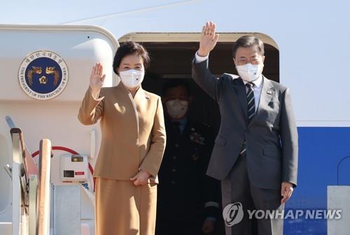 El presidente surcoreano, Moon Jae-in (dcha.), y la primera dama, Kim Jung-sook, saludan desde el avión presidencial, el 28 de octubre de 2021, en la Base Aérea de Seúl, en Seongnam, al sur de la capital surcoreana, antes de partir a Italia, para reunirse con el papa Francisco y celebrar una cumbre del Grupo de los 20 (G-20).