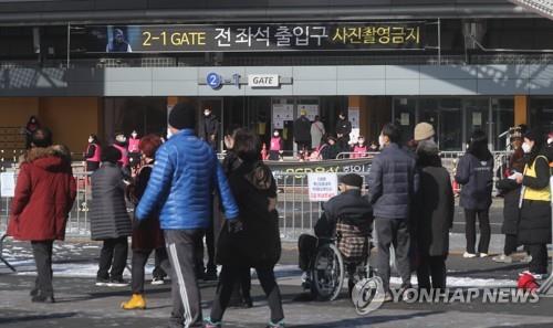 Los fanes esperan frente al Gimnasio Olímpico, en Seúl, el 19 de diciembre de 2021, para asistir a un concierto del popular cantante Na Hoon-a, en medio de un repunte de las infecciones por coronavirus.