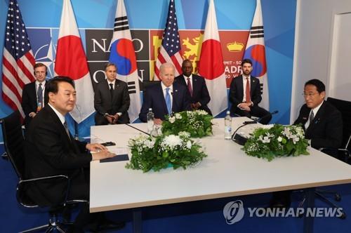 El presidente de Corea del Sur, Yoon Suk-yeol (izda.), el presidente de Estados Unidos, Joe Biden (centro), y el primer ministro japonés, Fumio Kishida, asisten a una cumbre trilateral celebrada, el 29 de junio de 2022, en el Centro de Convenciones de IFEMA, en Madrid, España.
