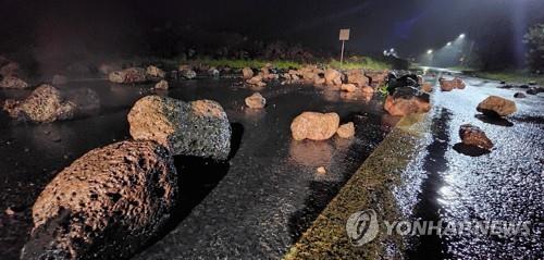 En la foto, tomada el 6 de septiembre de 2022, se muestra una carretera cubierta de rocas, en la sureña isla de Jeju, tras el impacto del tifón Hinnamnor. 