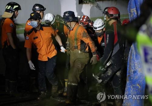 Los rescatistas atienden al sobreviviente de una inundación en un estacionamiento subterráneo de un edificio de apartamentos en Pohang, en la provincia de Gyeongsang del Norte, en el sudeste de Corea del Sur, el 6 de septiembre de 2022, después de que nueve residentes desaparecieran tras las lluvias torrenciales causadas por el tifón Hinnamnor, que azotó la región.