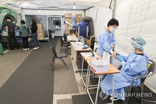 Los trabajadores sanitarios se preparan para trabajar en una clínica provisional del COVID-19, el 21 de septiembre de 2022, en un centro de salud comunitario, en el distrito de Seodaemun, en el oeste de Seúl.