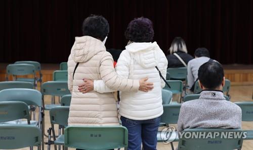 Las personas esperan en un centro de servicio comunitario, cerca del barrio de Itaewon, en Seúl, el 30 de octubre de 2022, después de reportar la desaparición de alguno de sus familiares.