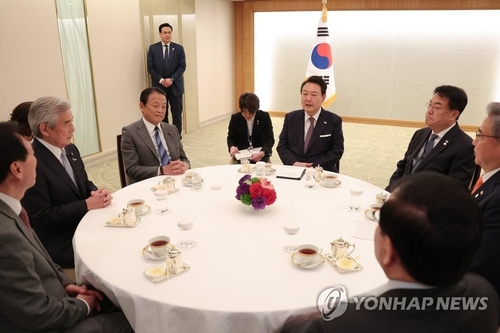 El presidente surcoreano, Yoon Suk Yeol (cuarto por la dcha.), se reúne con los miembros del Comité de Cooperación Japón-Corea del Sur, el 17 de marzo de 2023, en un hotel de Tokio.