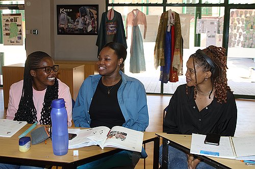 En esta foto de archivo, tomada el 14 de mayo de 2024, se muestra a unas estudiantes que asisten a un curso de idioma coreano en el centro del Instituto Rey Sejong, en Gaborone, Botsuana, hablando sobre la popularidad mundial de la cultura pop surcoreana.