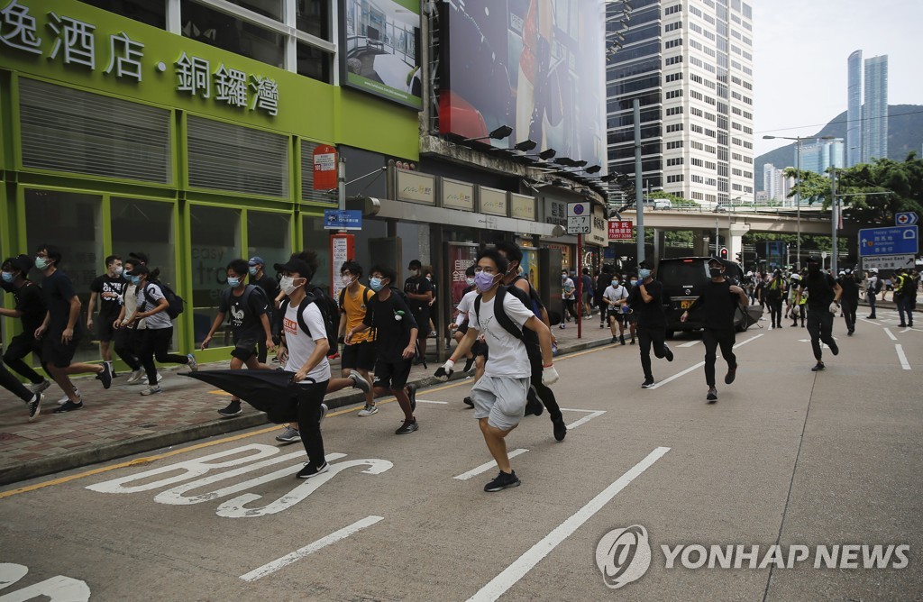 Protesters run during a protest against Beijing's national security legislation in Causeway Bay in Hong Kong on May 24, 2020, in this photo released by the Associated Press. (Yonhap)
