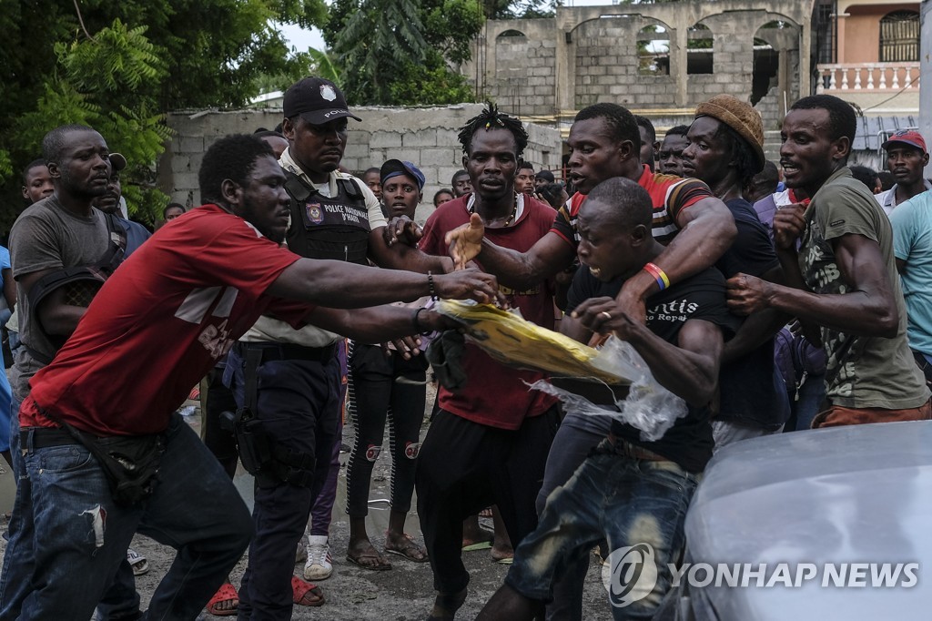 20일(현지시간) 구호물품 놓고 몸싸움하는 아이티 지진 피해자들