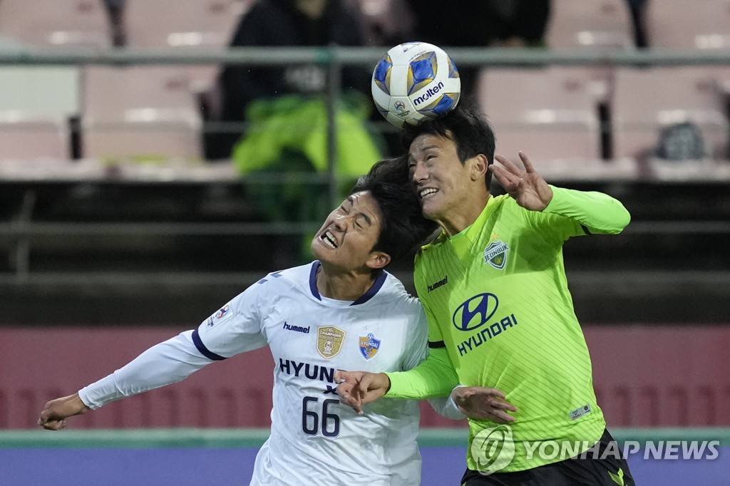 In this Associated Press photo, Seol Young-woo of Ulsan Hyundai FC (L) battles Han Kyo-won of Jeonbuk Hyundai Motors for the ball during the clubs' quarterfinal match of the Asian Football Confederation Champions League at Jeonju World Cup Stadium in Jeonju, 240 kilometers south of Seoul, on Oct. 17, 2021. (Yonhap)